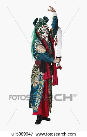 Stock Photo - Portrait of a male Chinese opera performer standing holding a sword. Fotosearch