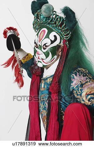 Stock Photo - Portrait of a male Chinese opera performer holding a weapon. Fotosearch
