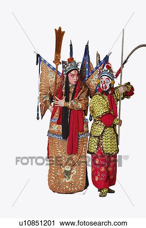 Stock Image - Two male Chinese opera performers gesturing with weapons. Fotosearch
