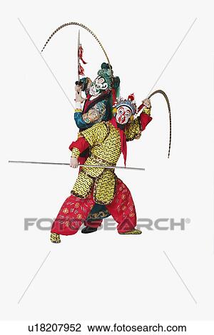 Stock Image - Two male Chinese opera performers gesturing with weapons. Fotosearch