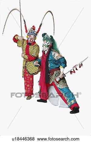 Stock Photo - Two male Chinese opera performers gesturing with weapons. Fotosearch