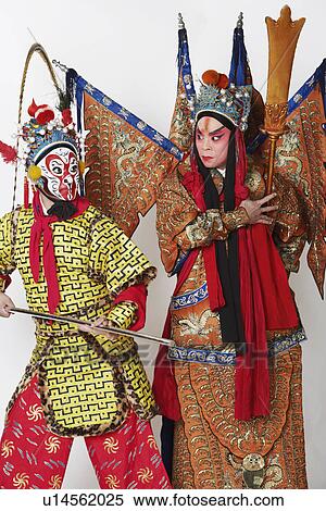 Stock Photography - Two male Chinese opera performers gesturing with weapons. Fotosearch