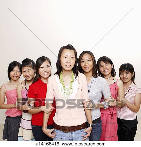 Stock Photograph - Portrait of a group of young women holding hands of each other and smiling. Fotosearch