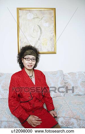 Portrait of a mature woman sitting on a couch View Large Photo Image Stock Image - Portrait of a mature woman sitting on a couch. Fotosearch