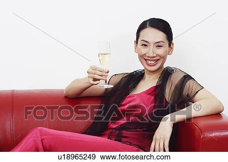 Portrait of a mid adult woman holding a champagne flute and smiling View Large Photo Image Stock Photo - Portrait of a mid adult woman holding a champagne flute and smiling. Fotosearch