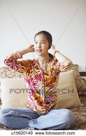 Young woman listening to music View Large Photo Image Stock Photo - Young woman listening to music. Fotosearch