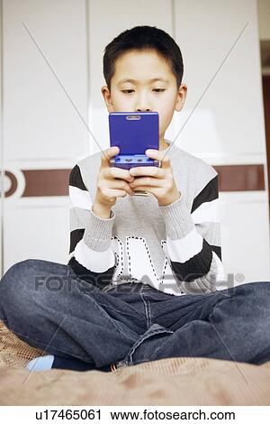 Stock Image - Boy playing a video game. Fotosearch