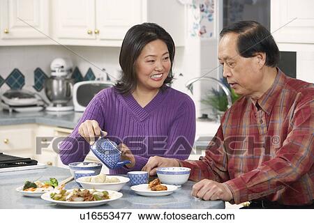 Close-up of a father looking at his daughter pouring tea View Large Photo Image Stock Photo - Close-up of a father looking at his daughter pouring tea. Fotosearch