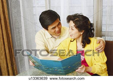 Close-up of a mature couple looking at each other with a young woman holding a document View Large Photo Image Stock Photo - Close-up of a mature couple looking at each other with a young woman holding a document. Fotosearch