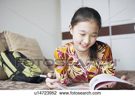 Close-up of a young woman reading a book View Large Photo Image Stock Image - Close-up of a young woman reading a book. Fotosearch