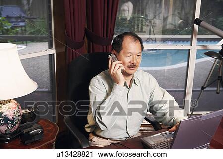 Stock Image - High angle view of a senior man talking on a cordless telephone. Fotosearch