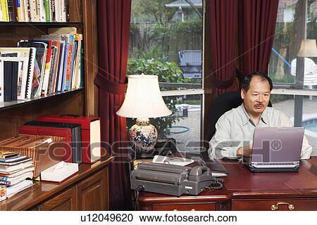 Stock Image - High angle view of a senior man using a laptop. Fotosearch