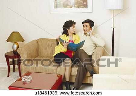 Mature man sitting on a couch with a mature woman talking on the telephone View Large Photo Image Stock Photograph - Mature man sitting on a couch with a mature woman talking on the telephone. Fotosearch