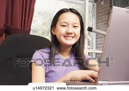 Portrait of a girl using a laptop View Large Photo Image Stock Image - Portrait of a girl using a laptop. Fotosearch