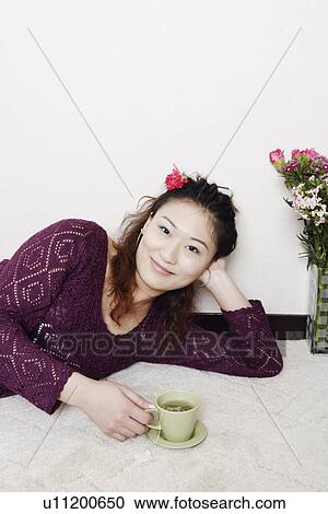 Portrait of a young woman holding a cup of tea View Large Photo Image Stock Image - Portrait of a young woman holding a cup of tea. Fotosearch