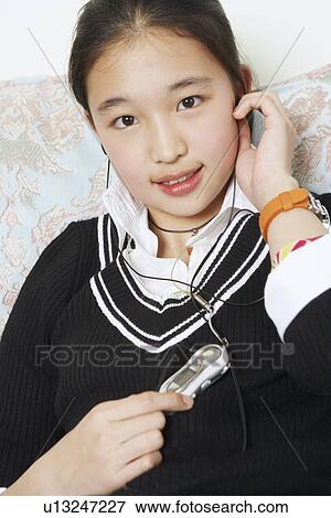 Portrait of a young woman listening to music on headphones View Large Photo Image Stock Photo - Portrait of a young woman listening to music on headphones. Fotosearch
