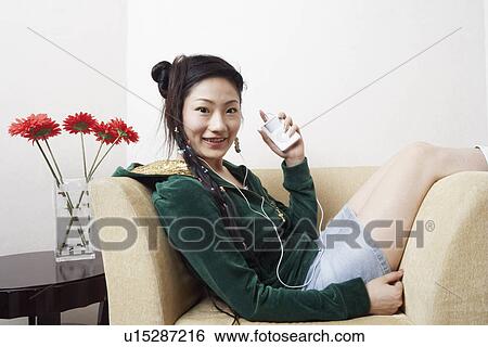 Portrait of a young woman listening to music View Large Photo Image Stock Photograph - Portrait of a young woman listening to music. Fotosearch