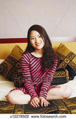 Stock Image - Portrait of a young woman sitting. Fotosearch
