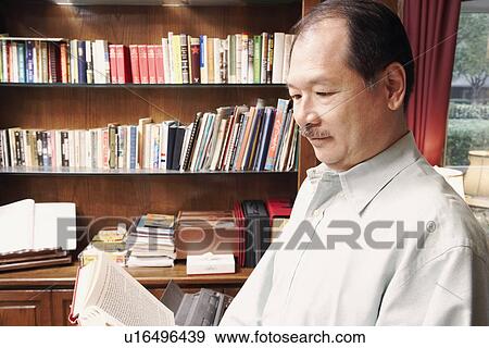 Stock Photo - Side profile of a senior man reading a book. Fotosearch