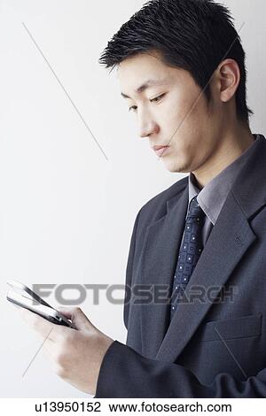 Close-up of a businessman looking at a mobile phone View Large Photo Image Stock Image - Close-up of a businessman looking at a mobile phone. Fotosearch