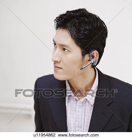 Stock Image - Close-up of a businessman standing with his hands in his pockets. Fotosearch