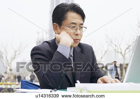 Stock Photo - Close-up of a businessman using a laptop. Fotosearch