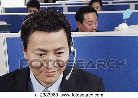 Stock Photo - Close-up of a businessman wearing headsets. Fotosearch