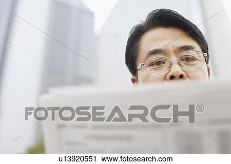 Close-up of a mature man reading a newspaper View Large Photo Image Stock Image - Close-up of a mature man reading a newspaper. Fotosearch