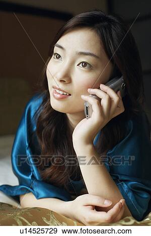 Close-up of a young woman talking on a mobile phone View Large Photo Image Stock Photo - Close-up of a young woman talking on a mobile phone. Fotosearch