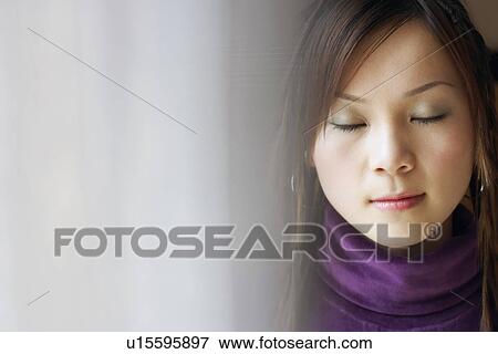 Close-up of a young woman with her eyes closed View Large Photo Image Stock Photo - Close-up of a young woman with her eyes closed. Fotosearch