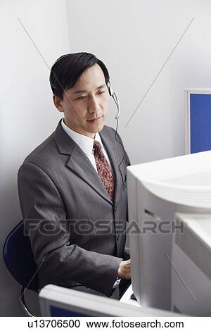 High angle view of a customer service representative working on a computer View Large Photo Image Stock Image - High angle view of a customer service representative working on a computer. Fotosearch