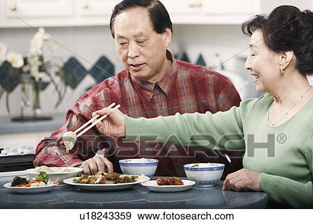 Stock Photo - Close-up of a senior couple sitting at a table. Fotosearch
