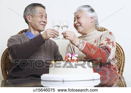 Stock Photography - Close-up of a senior couple toasting with wine glasses. Fotosearch