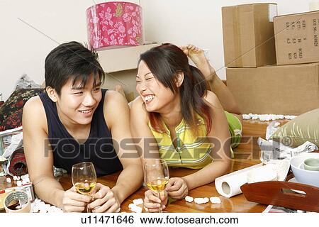 Close-up of a young couple lying on the floor and holding glasses of wine View Large Photo Image Stock Photograph - Close-up of a young couple lying on the floor and holding glasses of wine. Fotosearch