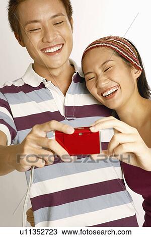 Close-up of a young couple taking a picture of themselves View Large Photo Image Stock Image - Close-up of a young couple taking a picture of themselves. Fotosearch