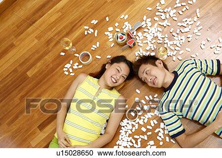 High angle view of a young couple lying on the floor and smiling View Large Photo Image Stock Image - High angle view of a young couple lying on the floor and smiling. Fotosearch