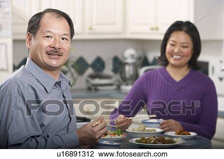Portrait of a couple eating food View Large Photo Image Stock Image - Portrait of a couple eating food. Fotosearch