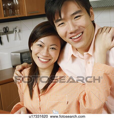 Portrait of a young couple smiling at a kitchen counter View Large Photo Image Stock Image - Portrait of a young couple smiling at a kitchen counter. Fotosearch