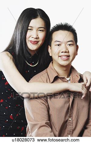 Portrait of a young woman embracing a young man from behind View Large Photo Image Stock Image - Portrait of a young woman embracing a young man from behind. Fotosearch