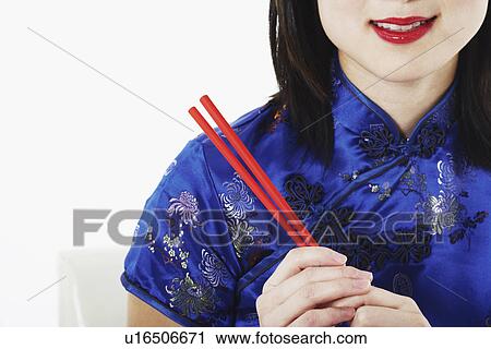 Close-up of a young woman holding chopsticks View Large Photo Image Stock Image - Close-up of a young woman holding chopsticks. Fotosearch