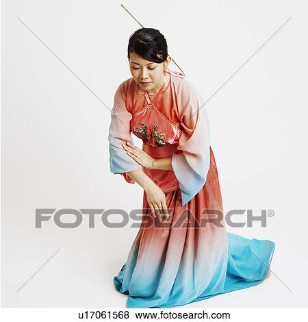 Stock Photo - Close-up of a young woman wearing traditional clothing and dancing. Fotosearch