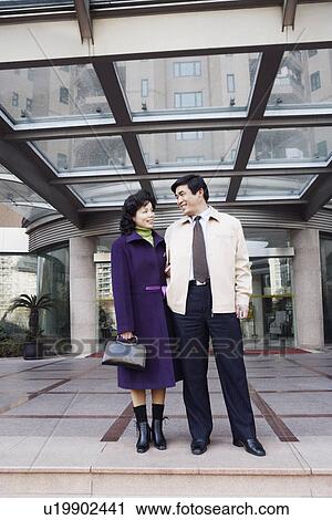 Low angle view of a mature couple looking at each other smiling View Large Photo Image Stock Image - Low angle view of a mature couple looking at each other smiling. Fotosearch