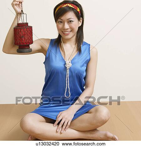 Stock Image - Portrait of a young woman holding a lantern. Fotosearch