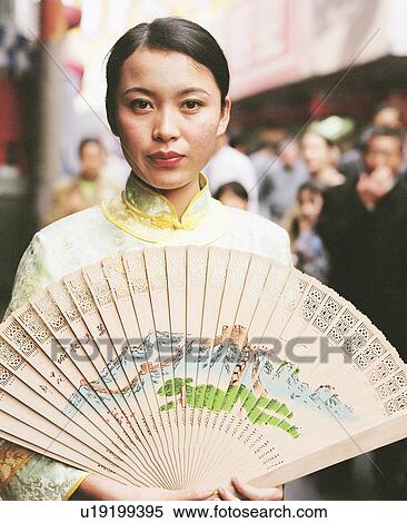 Portrait of a young woman in a traditional dress and holding a fan View Large Photo Image Stock Photography - Portrait of a young woman in a traditional dress and holding a fan. Fotosearch