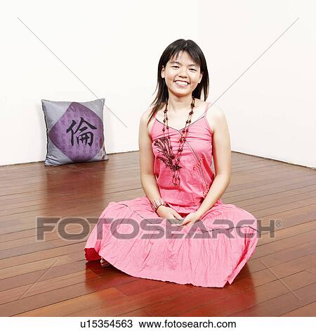 Stock Image - Portrait of a young woman looking cheerful. Fotosearch