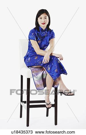 Stock Image - Portrait of a young woman sitting on a chair. Fotosearch