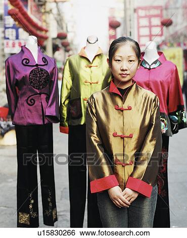 Stock Photograph - Portrait of a young woman standing in a traditional dress. Fotosearch