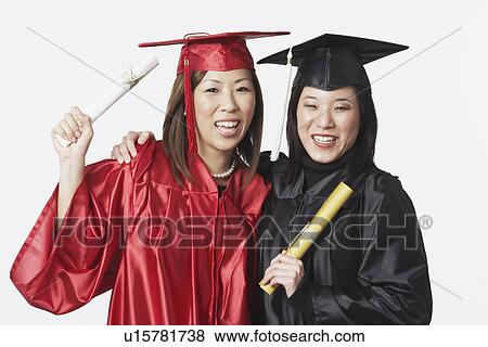 Stock Photo - Portrait of two female graduates holding diplomas. Fotosearch