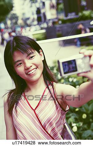 Close-up of a young woman taking a picture of herself View Large Photo Image Stock Photo - Close-up of a young woman taking a picture of herself. Fotosearch