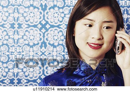 Picture - Close-up of a young woman talking on a mobile phone. Fotosearch
